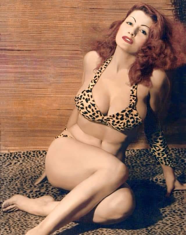 Tempest Storm sitting in a leopard skin bikini